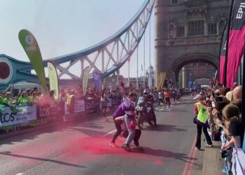 Διαδηλωτές πετούν κόκκινη σκόνη κατά τη διάρκεια του μαραθωνίου